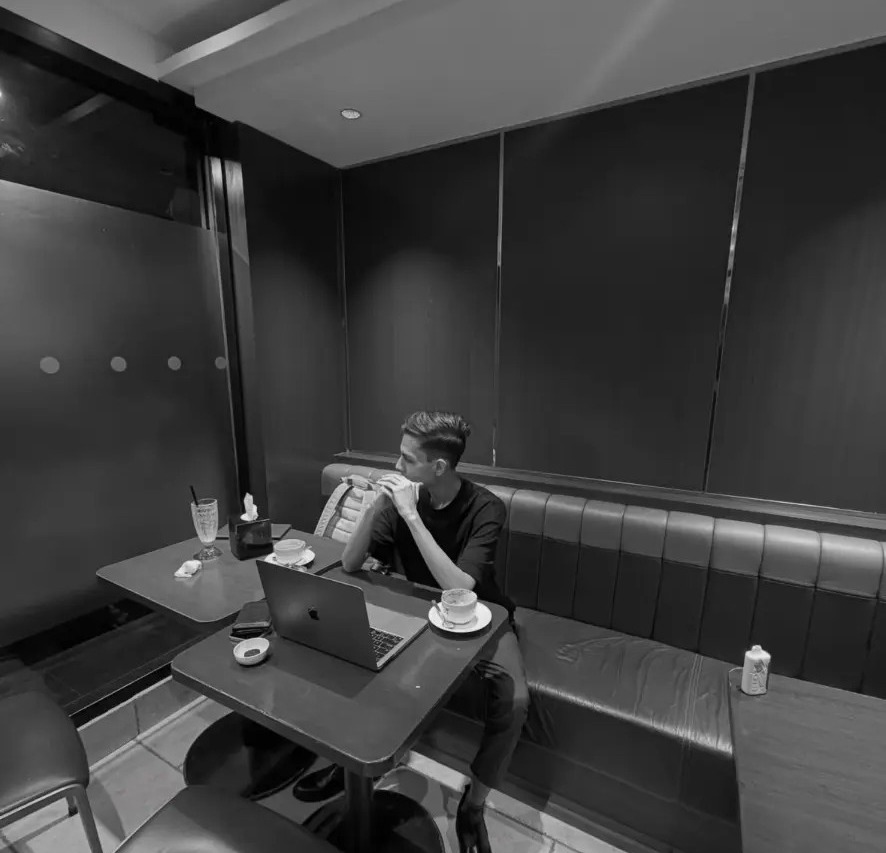 Furqan Sheikh working alone in a café in Pakistan